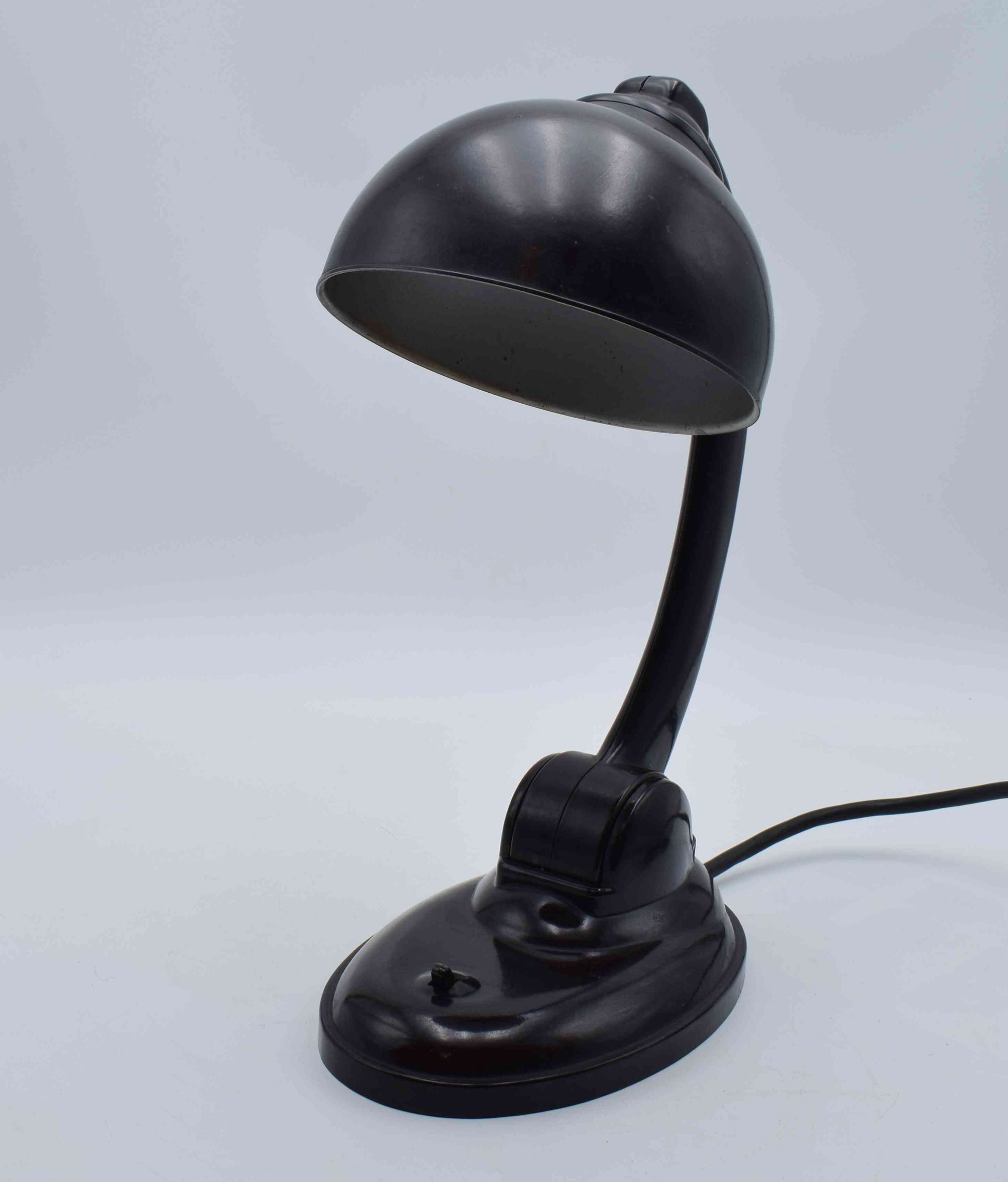 Black desk lamp on a light gray background