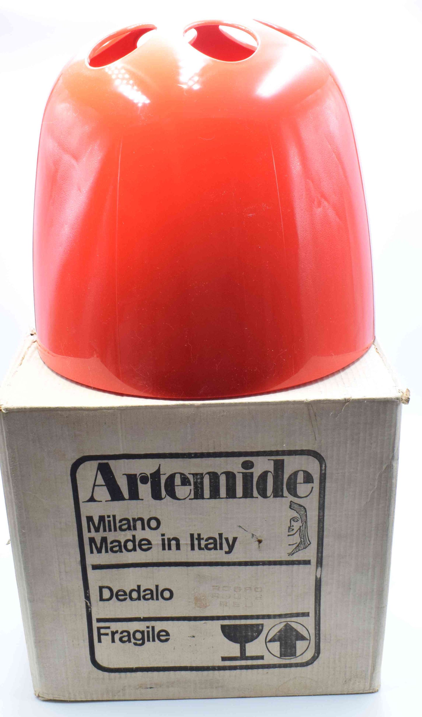 Red lampshade on a cardboard box with Artemide branding