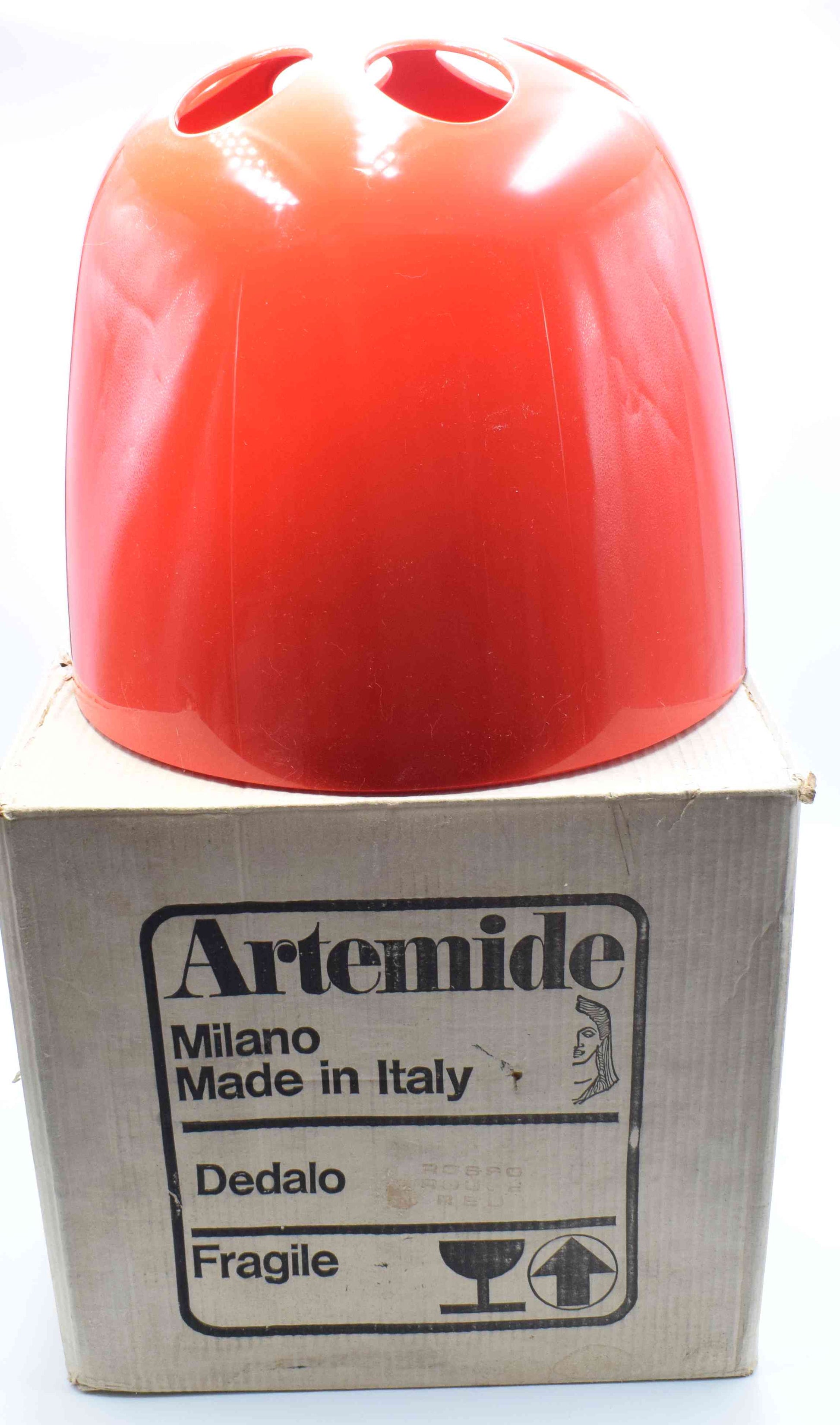 Red lampshade on a cardboard box with Artemide branding