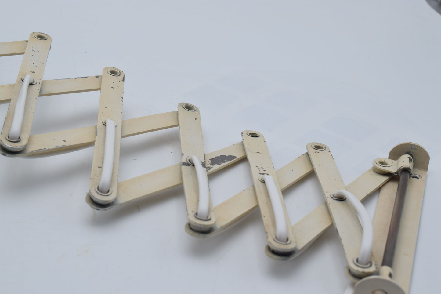 Mechanical arm model made of interconnected rods on a light gray background