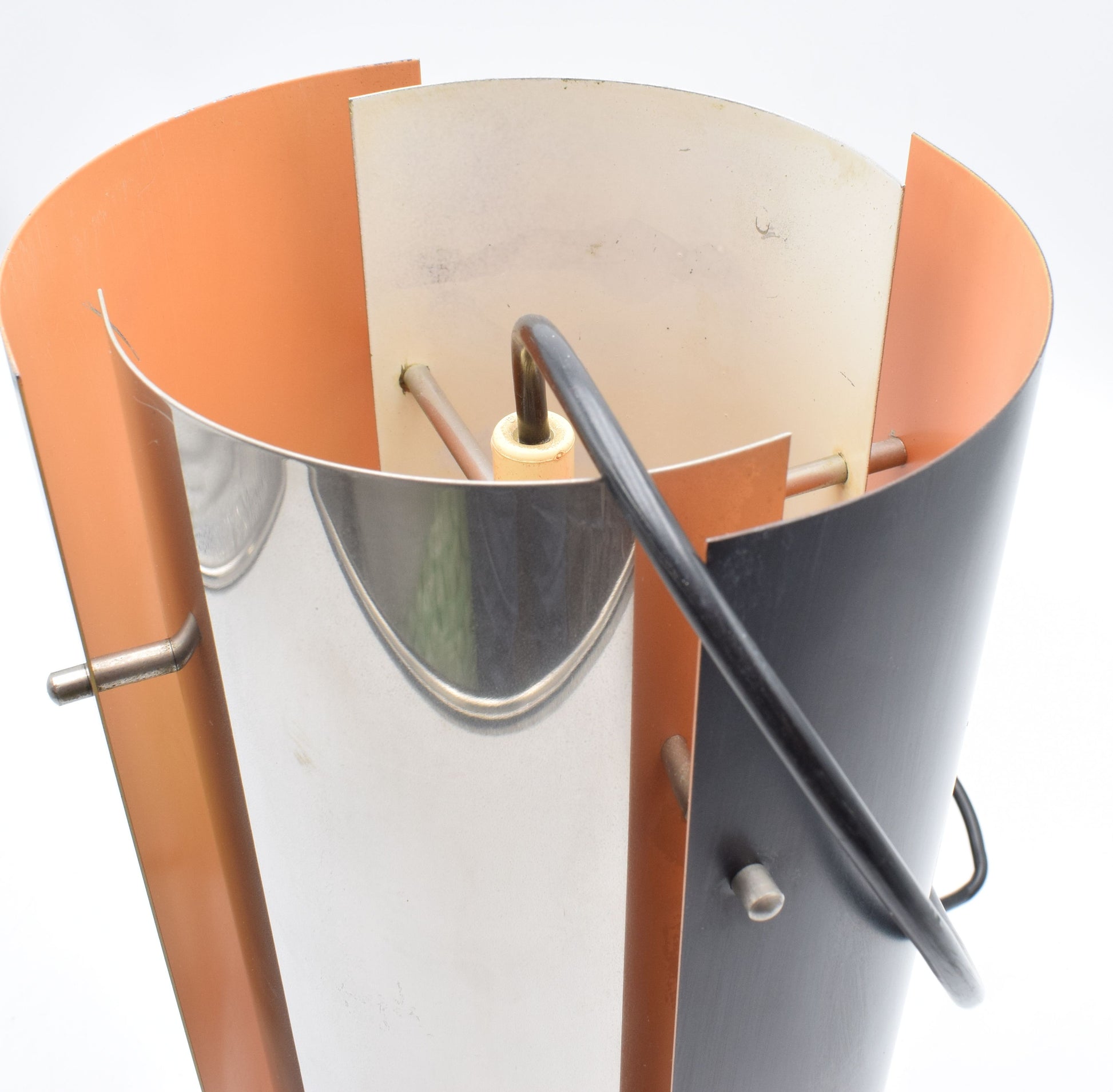 1970s Scandinavian pendant lamp with two black and two chrome quarter‑cylinder plates, chrome rods, and warm orange inner lacquer creating a directional glow