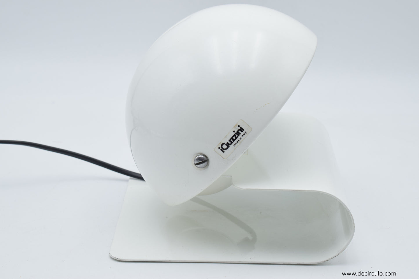 Side angle of the iGuzzini Bugia lamp showing the sculptural curved base and the hinged shade that opens to control the light output