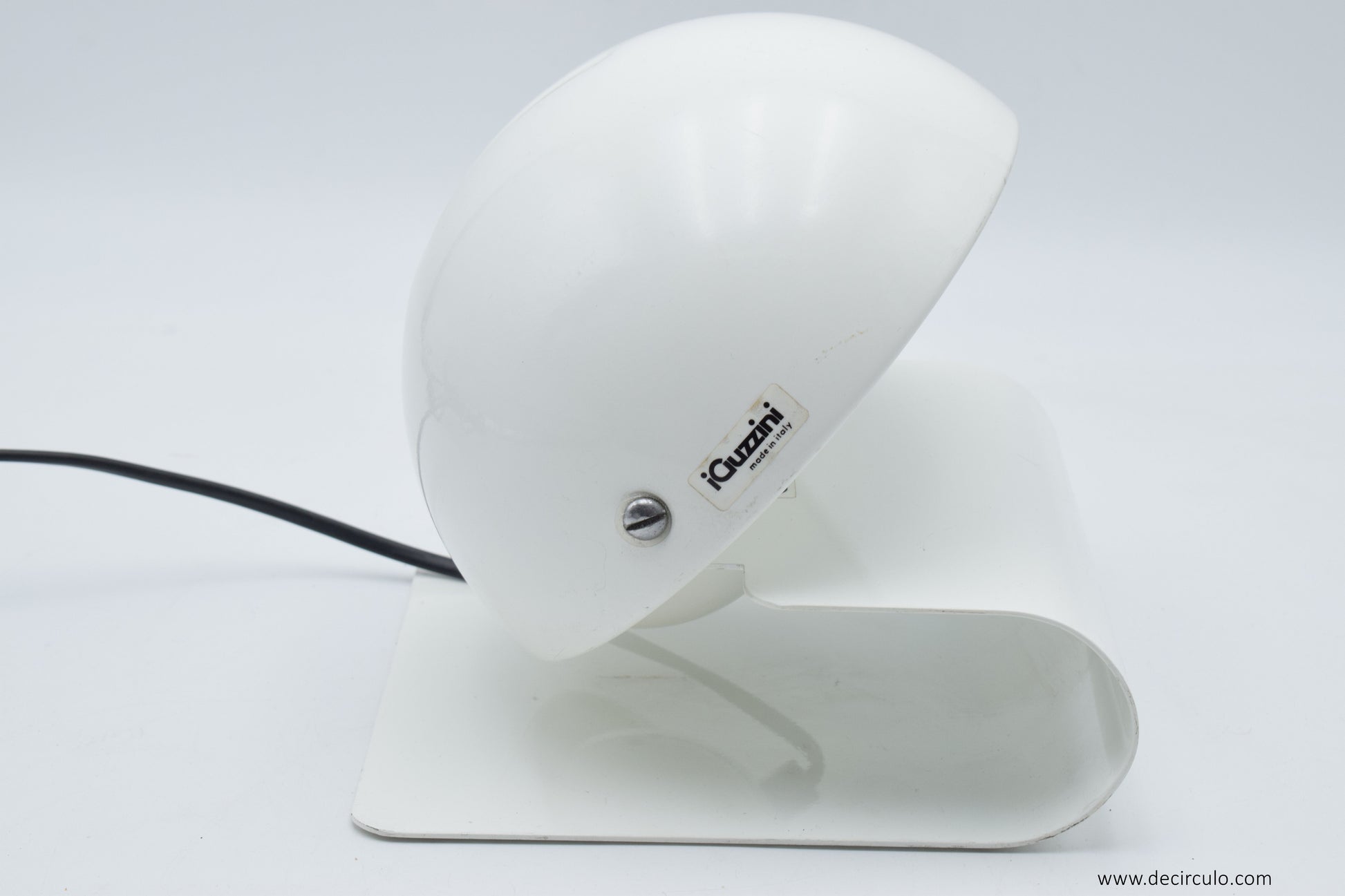 Side angle of the iGuzzini Bugia lamp showing the sculptural curved base and the hinged shade that opens to control the light output