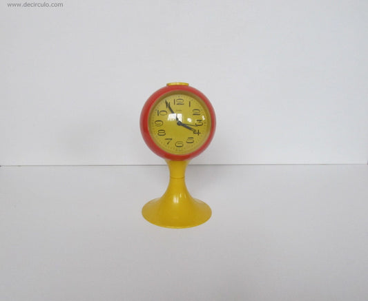 Reloj despertador amarillo naranja con pedestal en forma de tulipán, fabricado en Alemania. Era espacial, hecha de plástico desde principios de los años 1970
