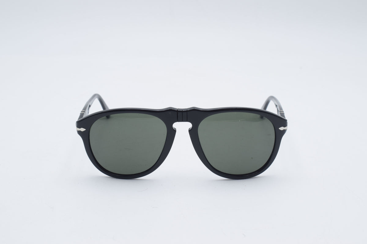 A pair of classic aviator-style sunglasses with a glossy black double bridge frame and dark green lenses, shown against a seamless light gray background.