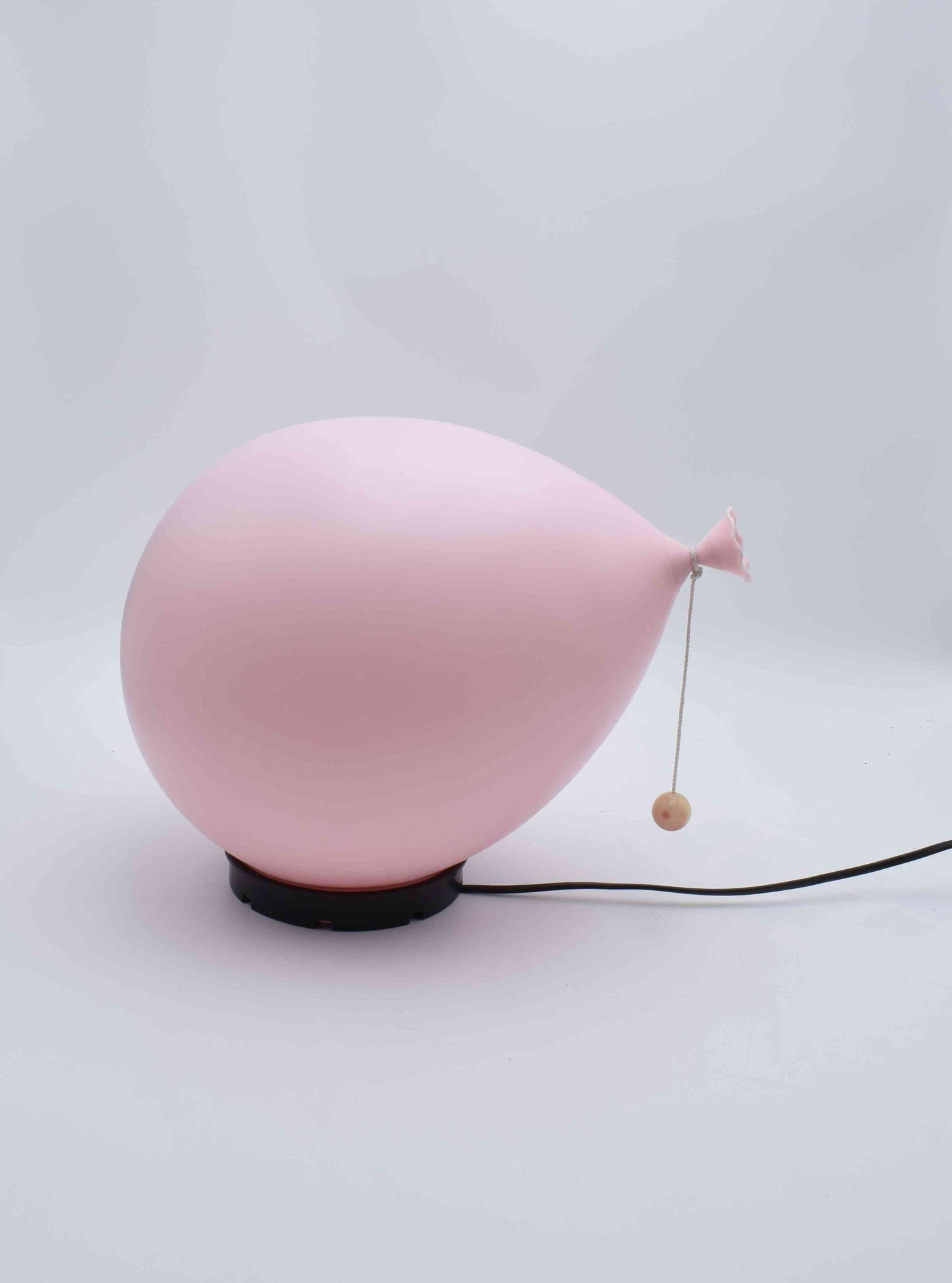 Pink balloon-shaped lamp on a white background