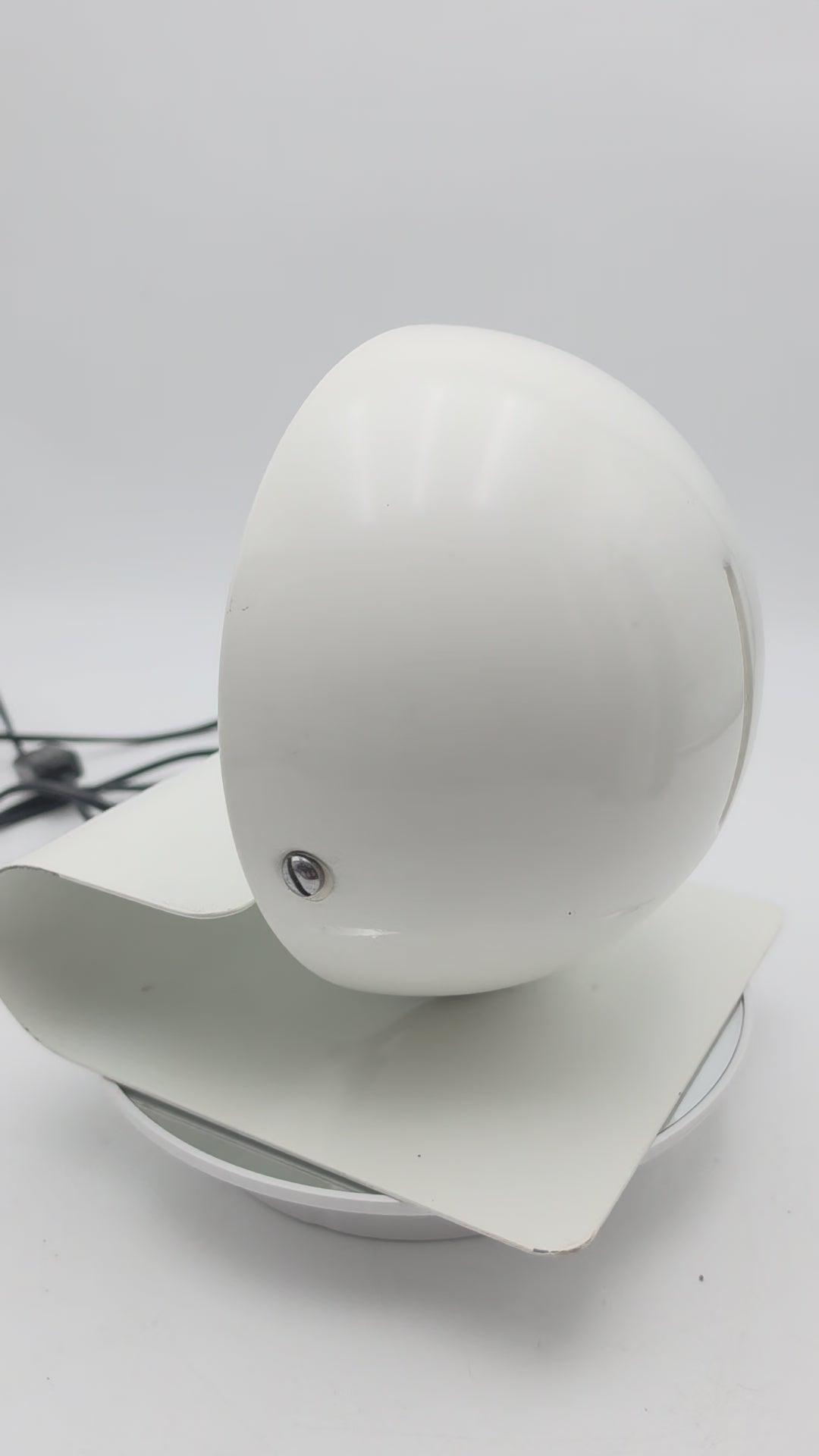 Bugia lamp in use, demonstrating the warm directional glow created when the adjustable shade is opened