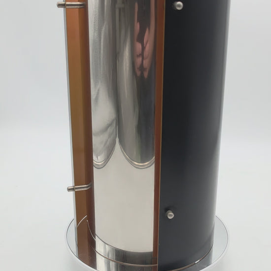 1970s Scandinavian pendant lamp with two black and two chrome quarter‑cylinder plates, chrome rods, and warm orange inner lacquer creating a directional glow
